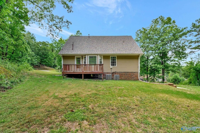 back of property with cooling unit, a wooden deck, and a yard