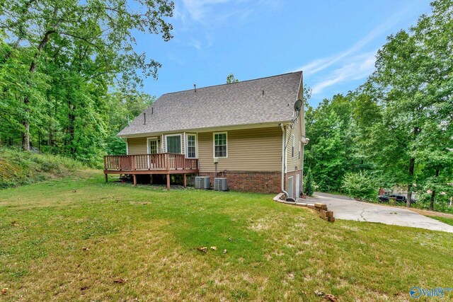 rear view of house with a deck, a lawn, and central AC unit