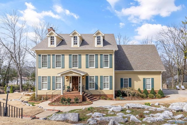 view of front of property featuring roof with shingles and a chimney