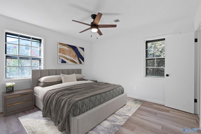 bedroom with light hardwood / wood-style flooring, multiple windows, and ceiling fan