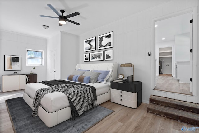 bedroom with light wood-type flooring, crown molding, ceiling fan, and a closet