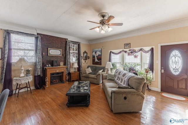 living room with a large fireplace, plenty of natural light, a textured ceiling, and light wood-type flooring