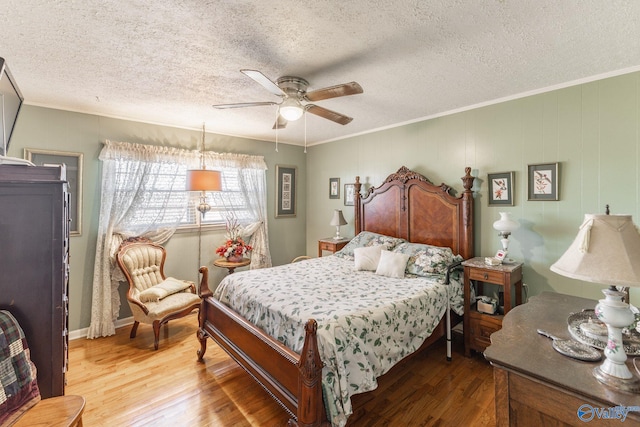 bedroom featuring wood-type flooring, crown molding, and ceiling fan