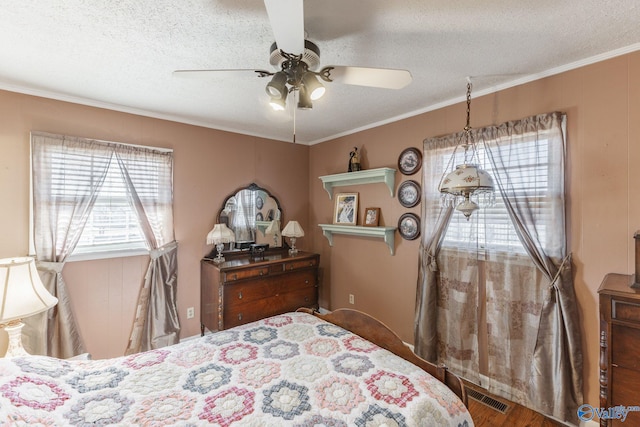 bedroom featuring a textured ceiling, ornamental molding, and ceiling fan