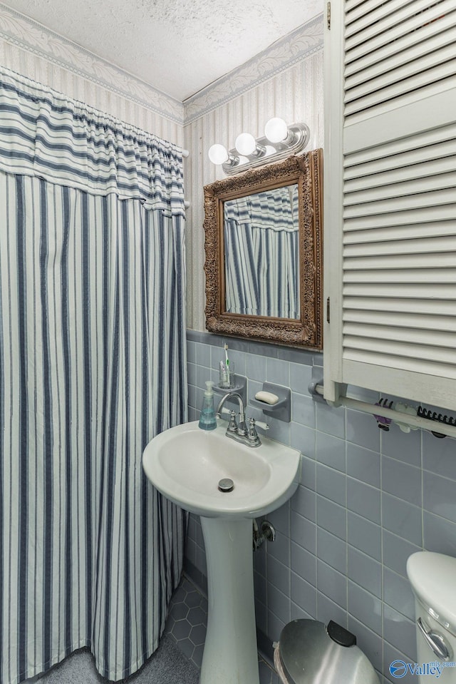 bathroom with tile patterned flooring and a textured ceiling