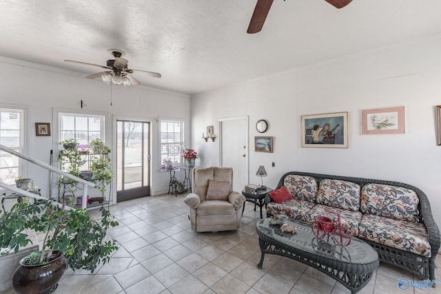 living room featuring ceiling fan, a textured ceiling, and light tile patterned floors