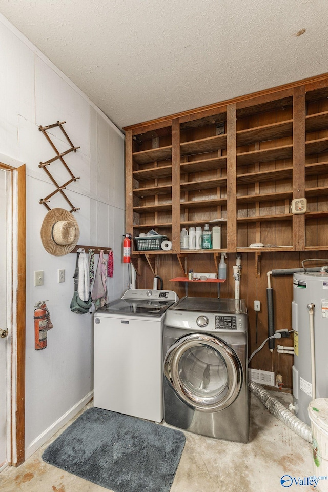 laundry room with washer and clothes dryer, water heater, and a textured ceiling