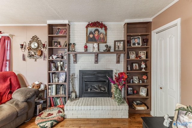 living room featuring hardwood / wood-style floors, a fireplace, ornamental molding, and a textured ceiling