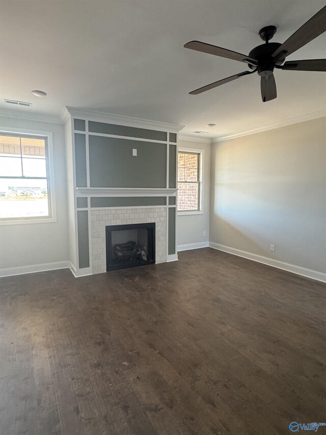 unfurnished living room featuring dark wood-style floors, a wealth of natural light, and crown molding