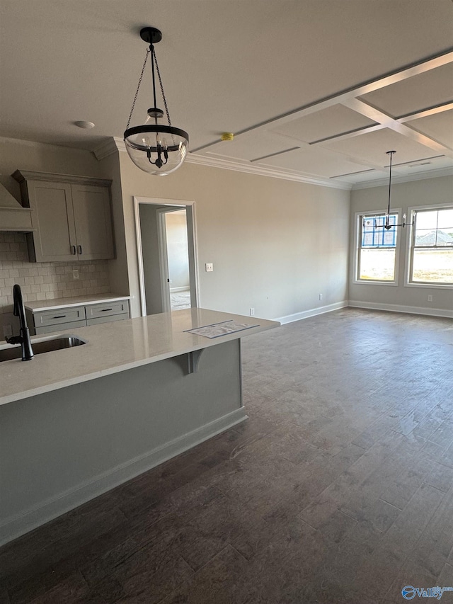 kitchen with gray cabinetry, a sink, light countertops, hanging light fixtures, and tasteful backsplash