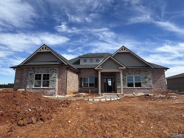 craftsman inspired home featuring brick siding and roof with shingles