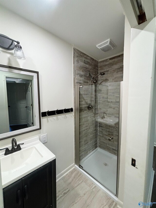 bathroom featuring a tile shower, visible vents, marble finish floor, and vanity