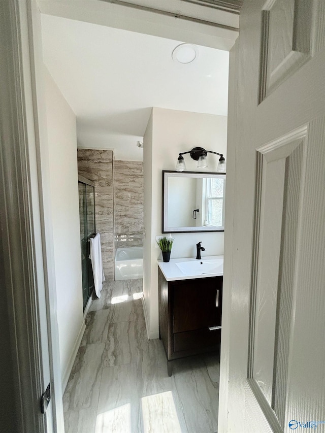 bathroom featuring a shower with door, marble finish floor, a washtub, and vanity
