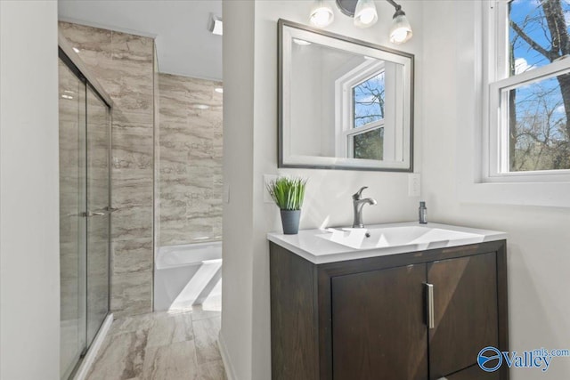 bathroom featuring a shower with door, a tub, and vanity