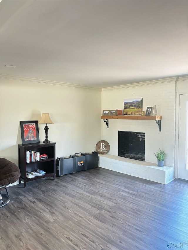 living room with crown molding, a fireplace, and wood finished floors