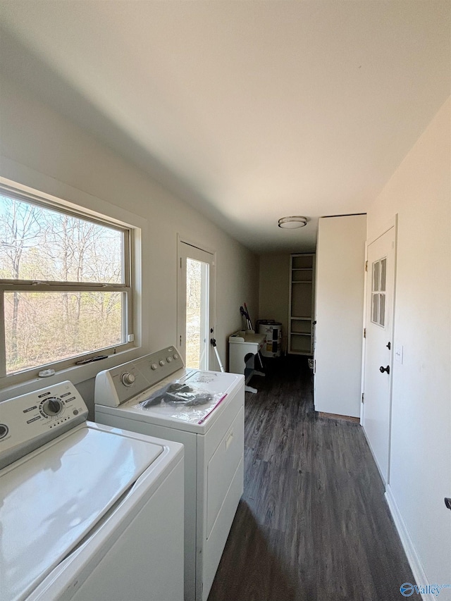 laundry area with laundry area, washing machine and dryer, and dark wood-type flooring