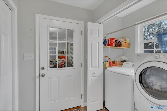 clothes washing area featuring washing machine and dryer and hardwood / wood-style flooring