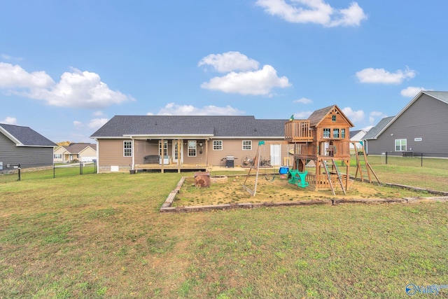 rear view of house with a playground and a yard