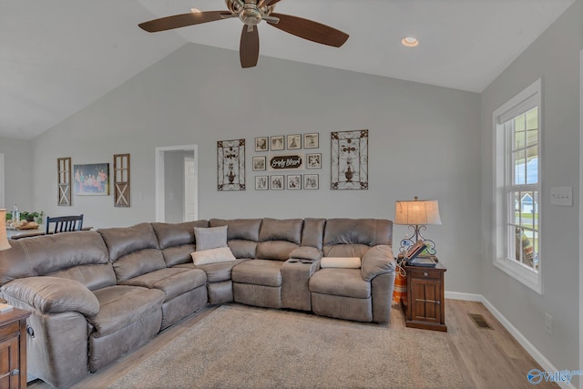 living room with ceiling fan, high vaulted ceiling, and light hardwood / wood-style flooring