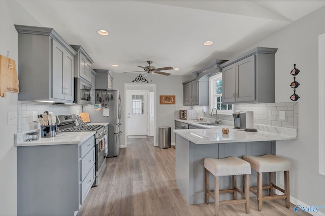 kitchen featuring stainless steel appliances, gray cabinetry, and sink