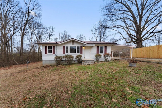 view of front of house with crawl space, an attached carport, a front yard, and fence