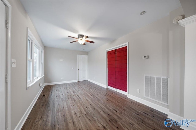 spare room featuring visible vents, baseboards, wood finished floors, and a ceiling fan