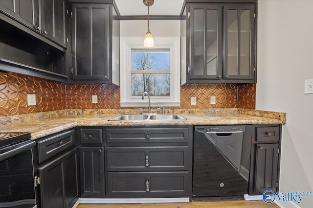 kitchen with black appliances, pendant lighting, a sink, backsplash, and dark cabinetry