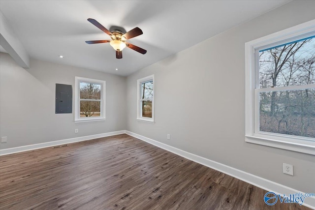 empty room featuring electric panel, baseboards, dark wood-style flooring, and ceiling fan