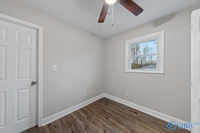 unfurnished room featuring visible vents, baseboards, dark wood-type flooring, and ceiling fan