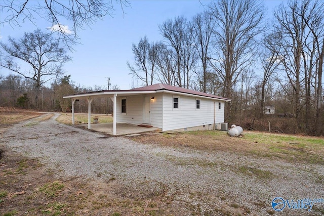 view of front facade featuring crawl space, central air condition unit, a carport, and driveway