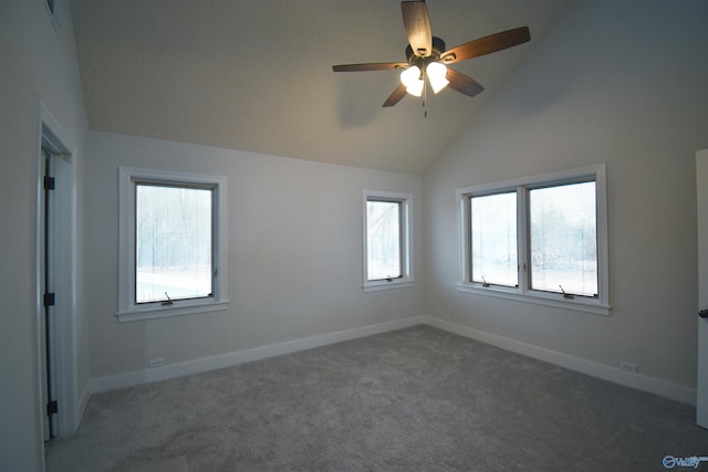 empty room featuring lofted ceiling, carpet floors, ceiling fan, and baseboards