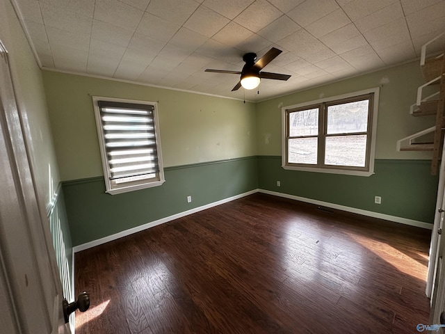 empty room featuring crown molding, ceiling fan, and dark hardwood / wood-style flooring