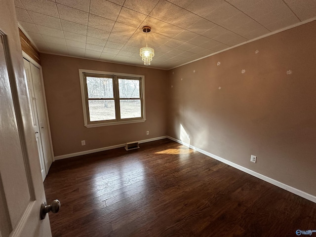 empty room featuring crown molding and dark hardwood / wood-style floors