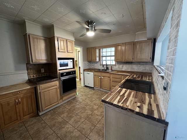 kitchen featuring sink, wooden counters, ceiling fan, tasteful backsplash, and black appliances