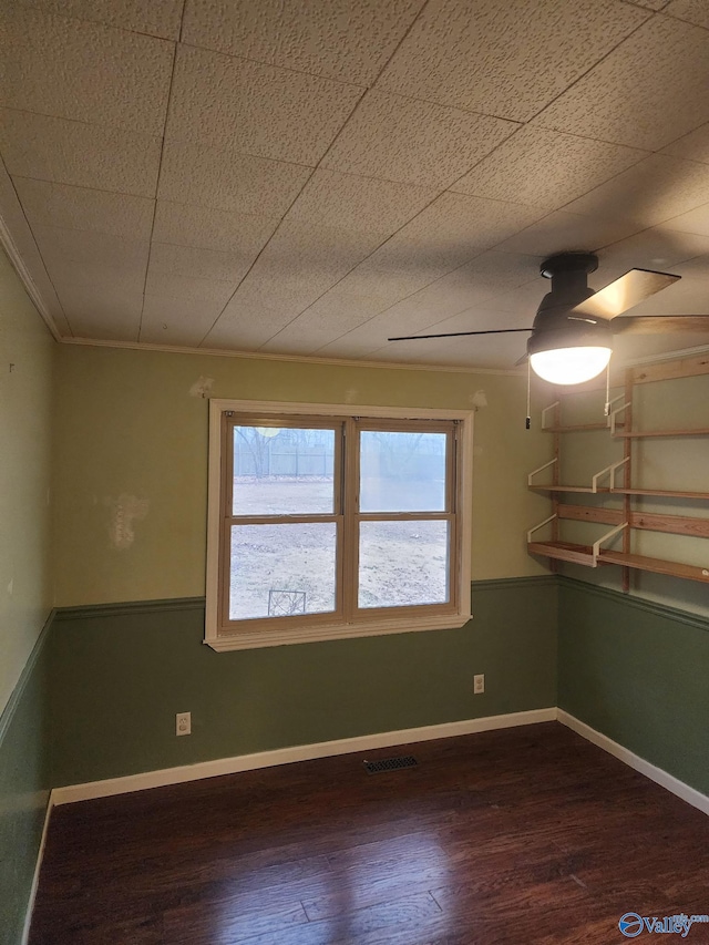 spare room with dark hardwood / wood-style flooring, ornamental molding, and ceiling fan