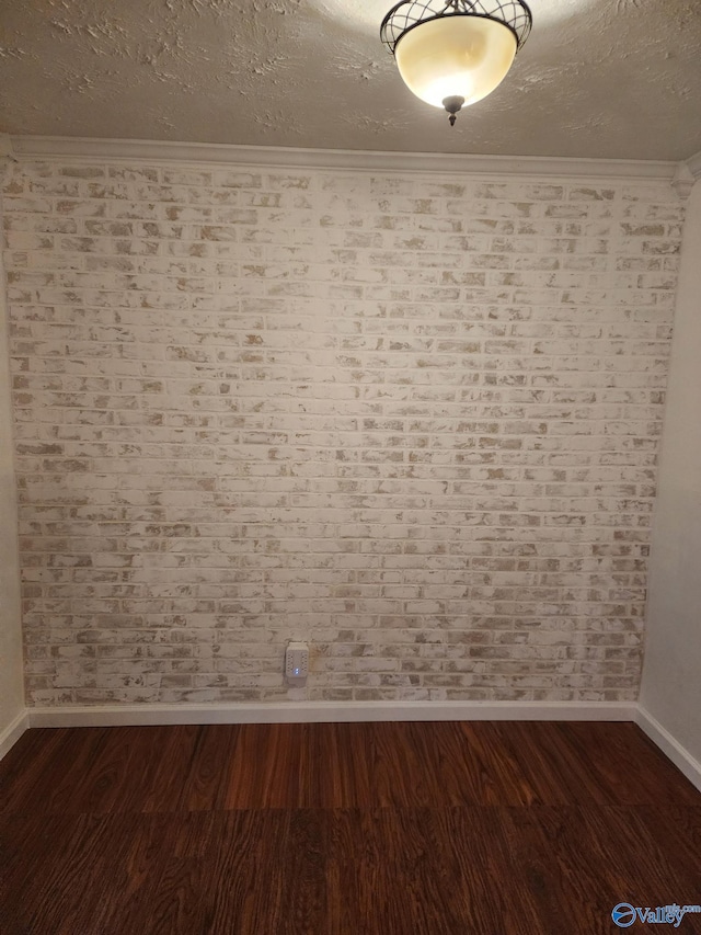 empty room with dark hardwood / wood-style flooring, crown molding, and a textured ceiling