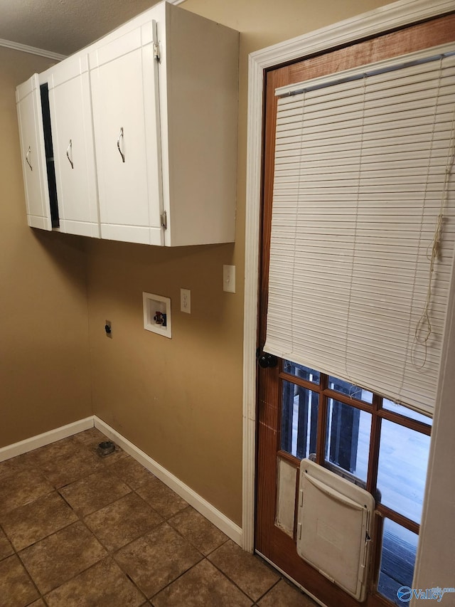 laundry area with cabinets, ornamental molding, dark tile patterned floors, washer hookup, and hookup for an electric dryer