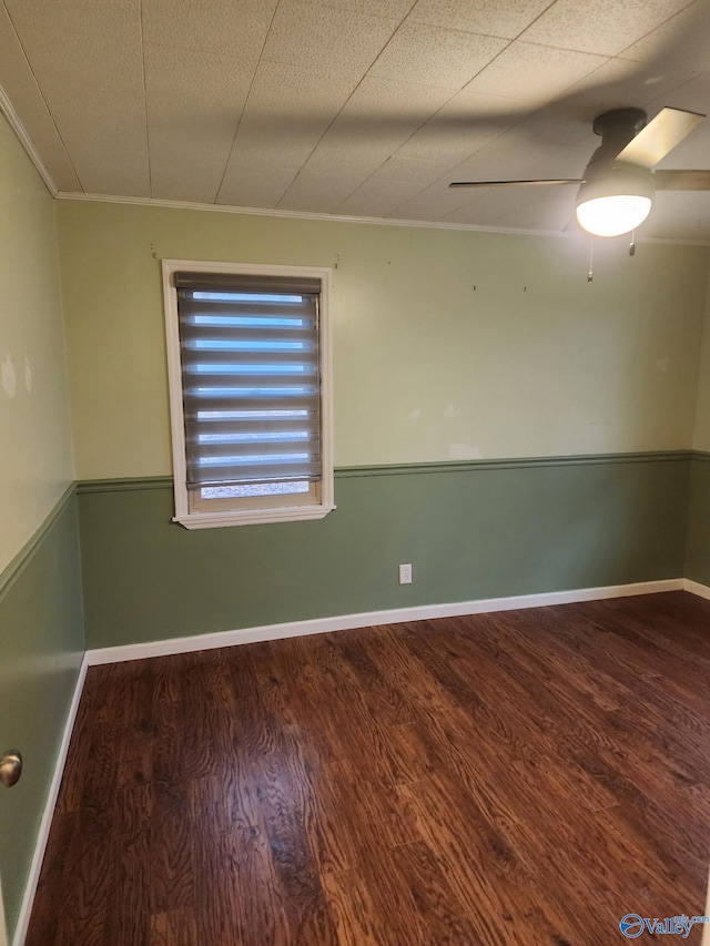 empty room featuring dark hardwood / wood-style flooring, a textured ceiling, ornamental molding, and ceiling fan