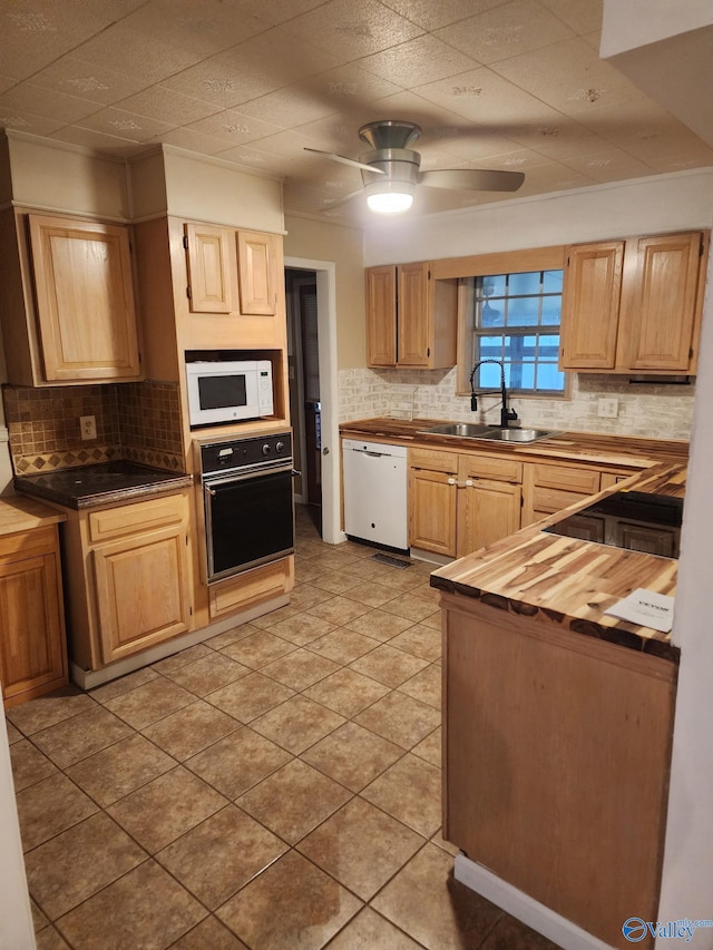 kitchen featuring butcher block countertops, sink, decorative backsplash, ceiling fan, and white appliances