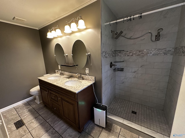 bathroom featuring vanity, crown molding, toilet, and tiled shower