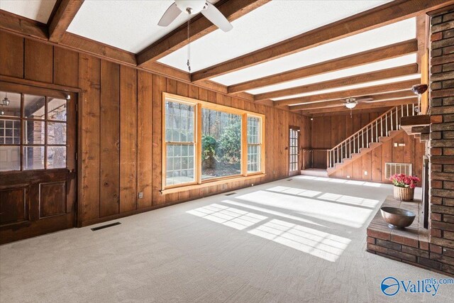 interior space featuring beam ceiling, ceiling fan, and carpet