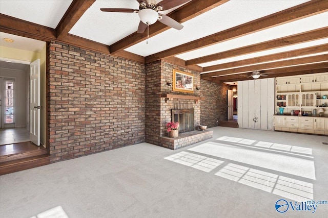 unfurnished living room featuring light carpet, a fireplace, brick wall, ceiling fan, and beamed ceiling