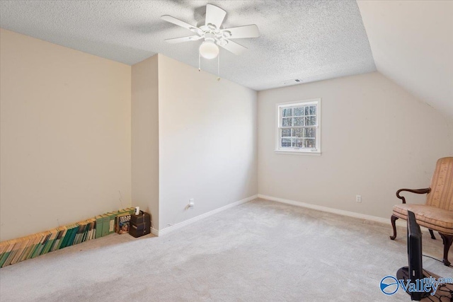 living area featuring ceiling fan, light colored carpet, lofted ceiling, and a textured ceiling