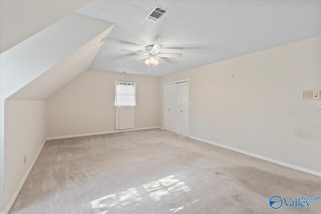 bonus room featuring light carpet, a textured ceiling, ceiling fan, and lofted ceiling