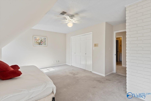 bedroom featuring light carpet, a textured ceiling, a closet, and ceiling fan