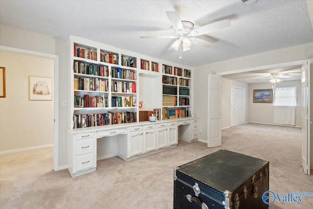 carpeted office with ceiling fan and a textured ceiling