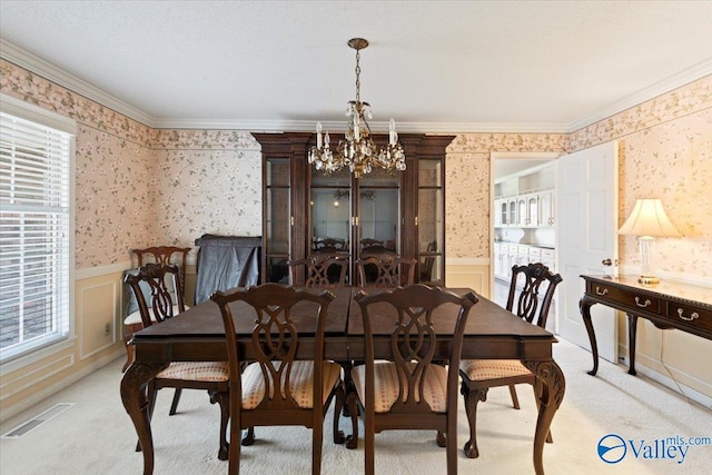 dining area with light colored carpet, an inviting chandelier, and ornamental molding