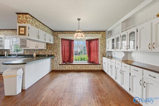 kitchen featuring a textured ceiling, white cabinetry, kitchen peninsula, and a wealth of natural light