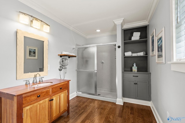 bathroom featuring ornamental molding, vanity, wood-type flooring, and a shower with door