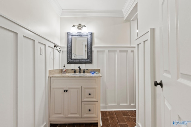 bathroom with vanity, ornamental molding, and hardwood / wood-style flooring